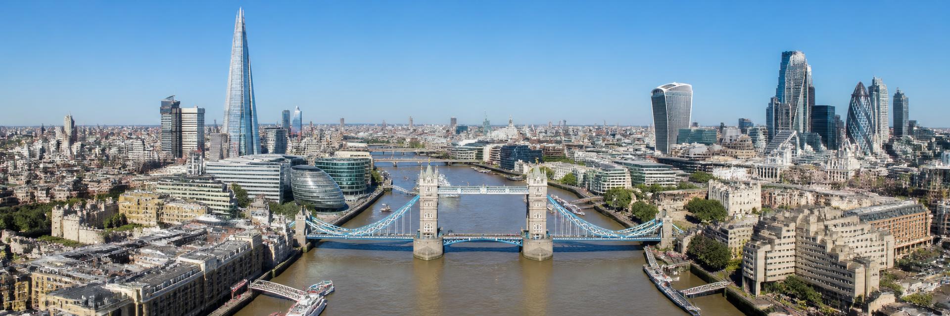 Aerial view of the River Thames, Tower Bridge and the City of London under a clear blue sky, where Honey-B2024 Ltd is based